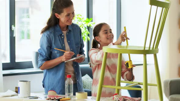 Mother and Daughter with Ruler Measuring Old Chair