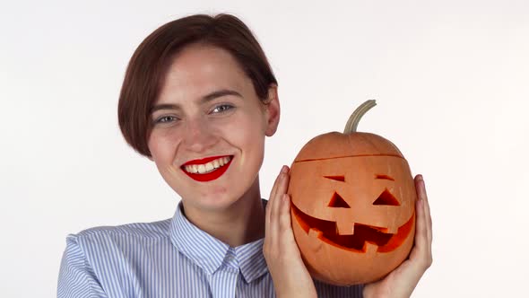 Beautiful Woman Smiling Joyfully Holding Up Halloween Pumpkin