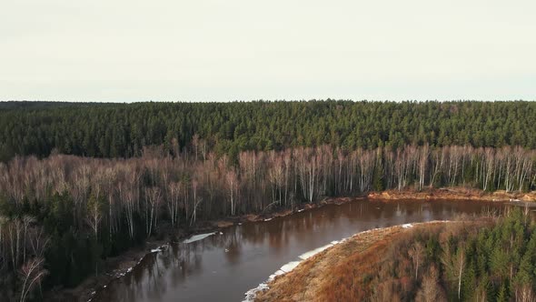 Melting Snow and Ice at River Gauja Near Beautiful Sand Cliff Cinematic Aerial