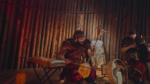 Man in Altai Clothes Plays Bow Instrument with Drummer