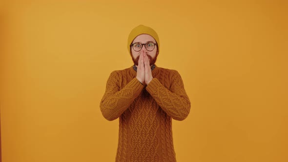 Surprised Man Covering His Face with His Palms  Orange Background