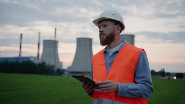 An Engineer in Helmet with a Tablet During a Check Power Plant