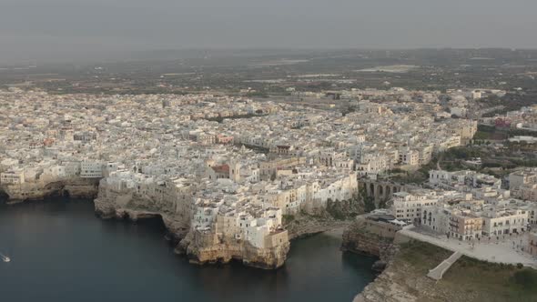 Aerial backwards view of Polignano a Mare in its extension. Italy