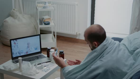 Sick Man Talking to Doctor on Video Call for Telemedicine