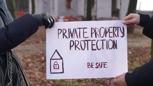 Closeup Private Property Protection Be Safe Banner in Female Caucasian Hands at Construction Site