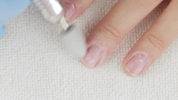 Young Woman Removes Gel Shellac Polish From Nails Using Manicure Machine