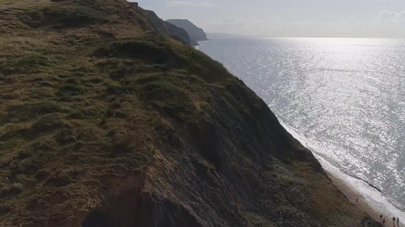 Aerial over the cliffs at Charmouth. Tracking close over the edge of the cliff to the east of the vi