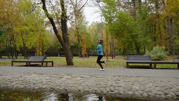 Slow Motion Jogger Running By River in Park