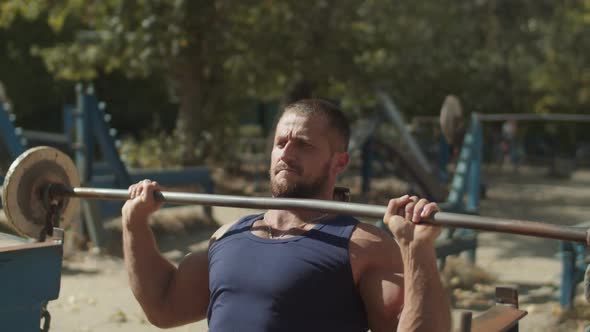 Man Working Out Lifting Barbell in Seated Position