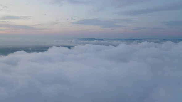 Aerial view of sunrise above fluffy sea fog misty clouds with mountain hill from Phu Tub Berk