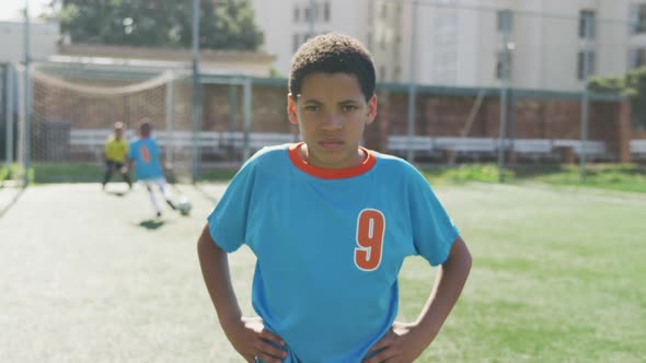 African American soccer kid in blue smiling and looking at camera