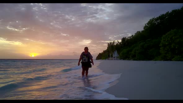 One woman suntans on tropical shore beach break by turquoise sea and white sand background of the Ma