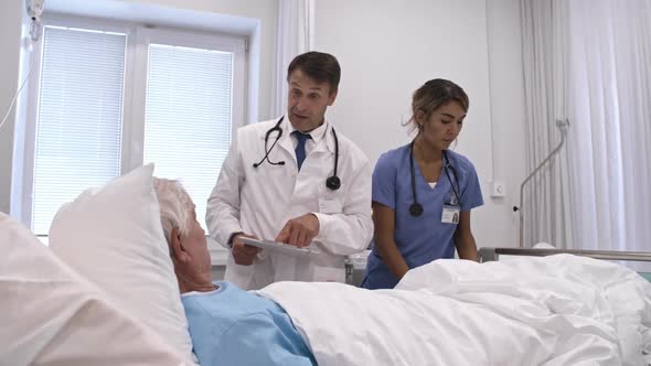 Doctor and Nurse Working with Patient in Comfortable Ward