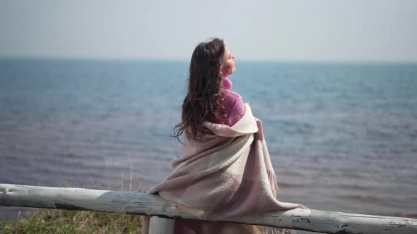 Satisfied Caucasian Woman Leaning on Wooden Fence Admiring River in Sunshine Outdoors