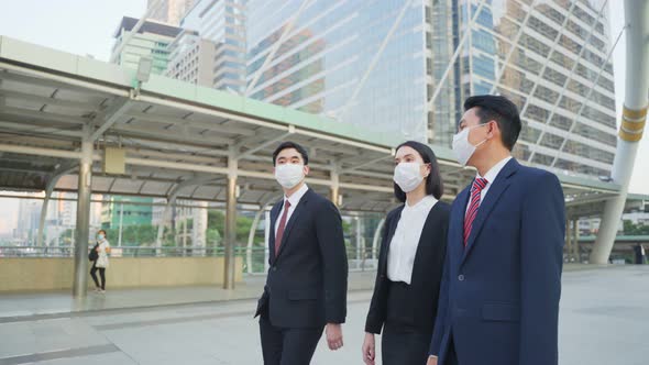 Group of young office businesspeople wear mask, walking outdoor in city with new normal lifestyle.