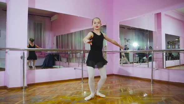 Ballerina dancing in studio in front of mirror. In the ballet hall. A little dancer. Slow motion.