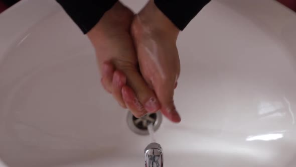 Man Washes His Hands with Soap