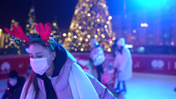 People Enjoy Ice Skating in the Street Around Christmas Tree in Rink