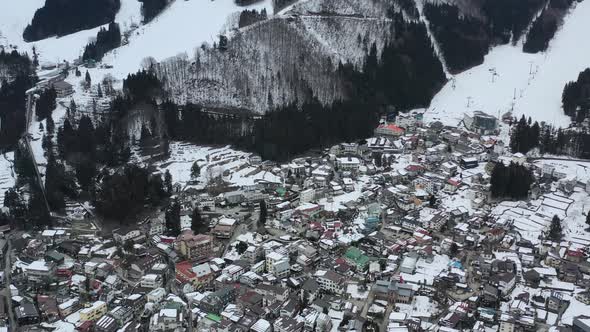 residential homes in mountain ski resort village of nazawa onsen during winter, aerial