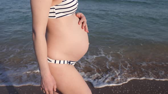 Pregnant Woman Walking In Bikini By The Sea.