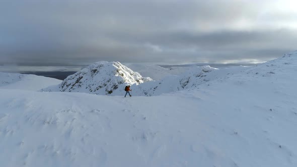 Mountain Climber Walking Along a Snowy Ridge