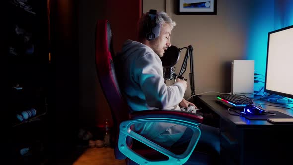 Young man sitting at computer playing video game