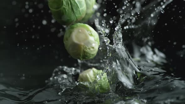 Throwing brussels sprout into water. Slow Motion.