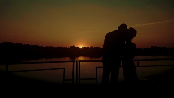 Two Young People Hugging Against the Backdrop of a Sunset By the River Closeup 2