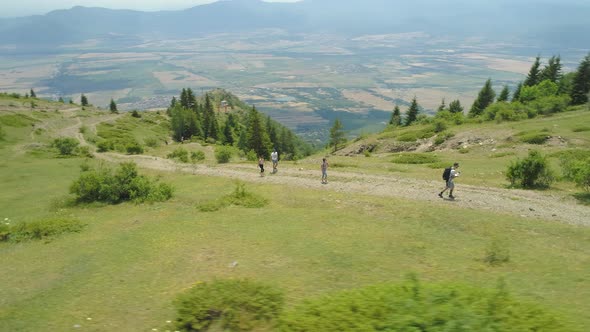 Group of Tourists Walk Along a Path on a Mountain Range