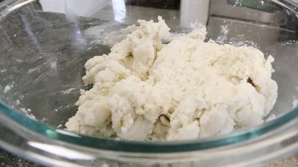 dolly shot of pie crust dough in glass bowl