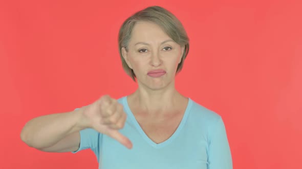 Thumbs Down By Old Woman on Red Background