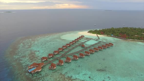 Aerial view of overwaters bungalows connected by a footbridge, Maldives.