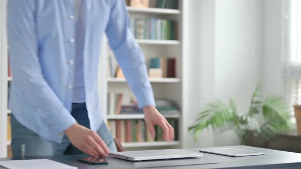 Man Coming Back and Opening Laptop in Office