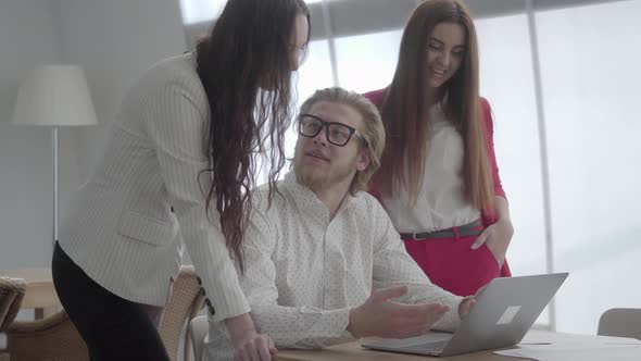 Portrait Successful Blond Man in Glasses Sitting in a Light Comfortable Office