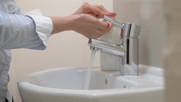 Woman washing hands with soap to protect from virus