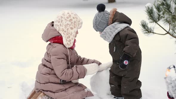 Children i Building a Snowman on a Winter Day at Backyard