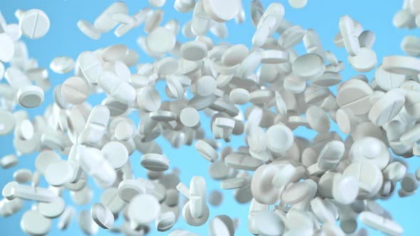 Super Slow Motion Shot of Flying White Pills on Blue Background at 1000Fps.