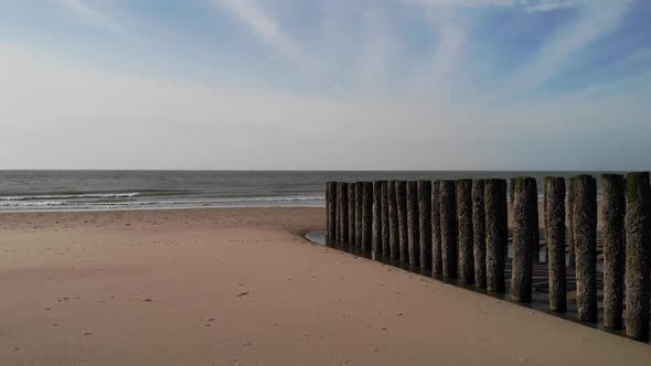 Scenic View Of Sandy Beach With Old Wood Pilings Near The Shore In Brouwersdam, Netherlands - wide s
