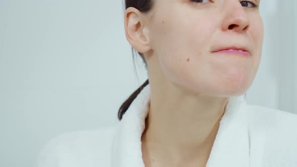 Smiling Woman Washing Her Teeth in Front of Mirror