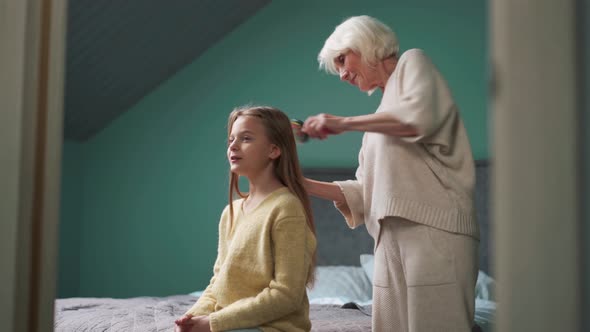 Grandmother combing her granddaughter's hair