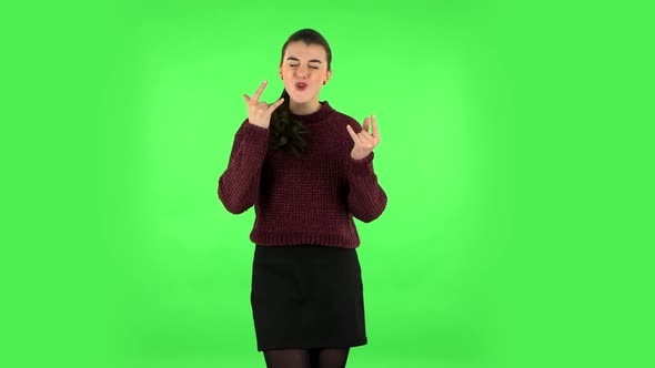 Female Making a Rock Gesture, Enjoying Life and Laughing. Green Screen