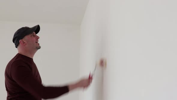 Man paints the wall with a roller