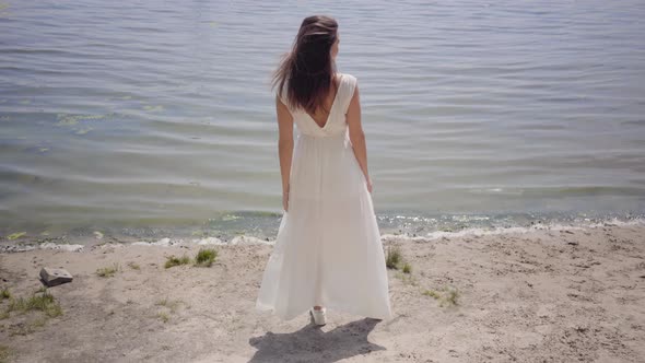 Portrait Beautiful Young Girl with Long Brunette Hair Wearing a Long White Summer Fashion Dress