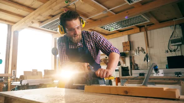 Slow Motion of a Male Carpenter Using a Jigsaw To Cut the Wood