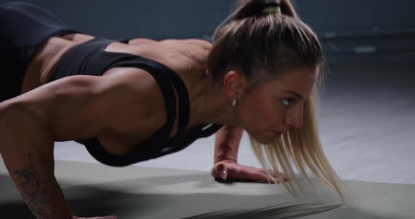 Muscular Woman Doing Pushups in the Gym