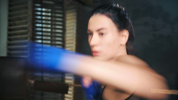 Closeup Professional Girl of Mixed Martial Arts Beating By Arm in Gloves at Dark Kickboxing Studio