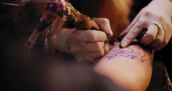 Tattoo artist making a tattoo of a deer on a person's hand. BMPCC 4K