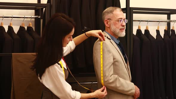 a Professional Tailor Woman Trying on a Tailormade Suit for an Elderly Man