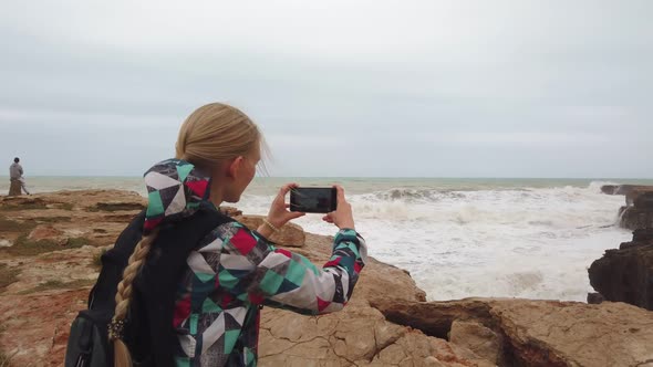 Girl Stands with Her Back and Takes a Photo on Her Cell Phone the Sea. Slow Motion