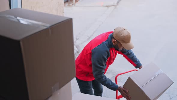 Young Man Unloading Cardboard Boxes From the Truck